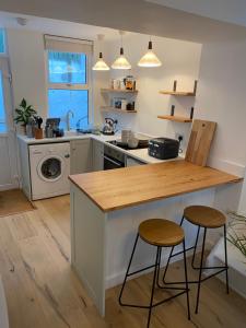 a kitchen with a counter and two stools at Cheerful one bedroom cottage in Mousehole. in Mousehole