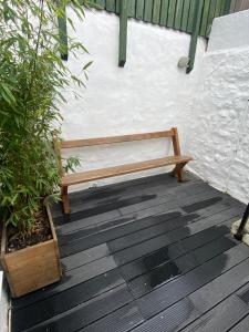 a wooden bench sitting on top of a wooden deck at Cheerful one bedroom cottage in Mousehole. in Mousehole