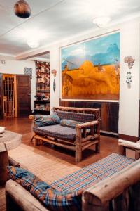 a living room with wooden furniture and a painting on the wall at Adventures Nest in Moshi