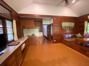 a kitchen with wooden cabinets and a couch in a room at Smile House - Fisherman Village in Bophut