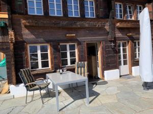 uma mesa e duas cadeiras em frente a um edifício em Büehl Lenk em Lenk