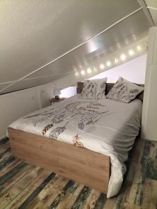 een slaapkamer met een bed met een houten bedframe bij Au bord du lac in Royère-de-Vassivière