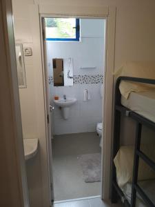 a small bathroom with a sink and a toilet at Hostel de las Facultades in Santander