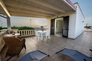 un patio con tavolo e sedie sul balcone. di Casa Rebecca a Torre San Giovanni Ugento