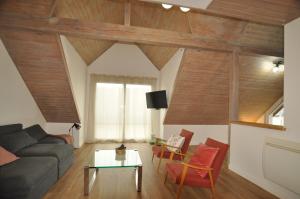ein Wohnzimmer mit einem Sofa und einem Tisch in der Unterkunft L'Hirondelle - Charming flat - in Blotzheim