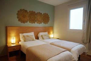 two beds in a hotel room with two lamps at Evasion Corse Direct mer Piscine Terrasse in Moriani Plage +25 photos