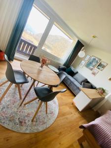 un soggiorno con tavolo, sedie e divano di Seeblickplatzl 220 - mit Seeblick zum Wolfgangsee a Strobl