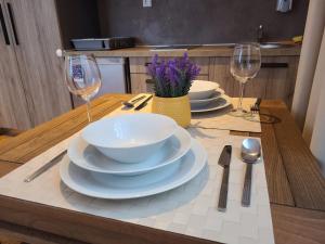 - une table avec des assiettes, des bols et des verres à vin dans l'établissement Bela Brada - Brzeće, Kopaonik, à Brzeće