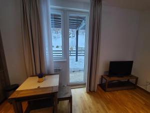 un salon avec une table et une grande fenêtre dans l'établissement Bela Brada - Brzeće, Kopaonik, à Brzeće 5 autres photos
