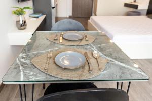 einen Tisch mit einem Teller und Küchenutensilien darauf in der Unterkunft F-Hotel & Apartment in Ho-Chi-Minh-Stadt