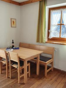 a dining room table with chairs and a window at Kachelofenwohnung Pölzleitner in Annaberg im Lammertal