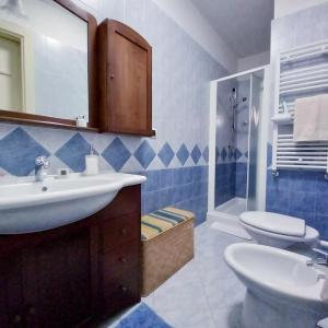 a blue and white bathroom with a sink and a toilet at La Dimora del Porto in Bisceglie +15 photos