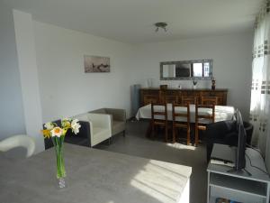 ein Wohnzimmer mit einem Tisch und einer Blumenvase in der Unterkunft Au pied du Pertuiset in Drumettaz-Clarafond