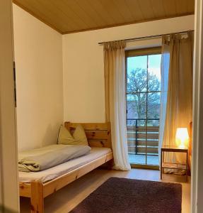 a bedroom with a bed and a large window at Neubauernhof in Schwarzenbruck