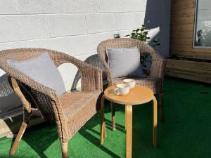 two wicker chairs and a table on a patio at The Corner House - Modern Chesterfield Town Centre Apartments in Chesterfield