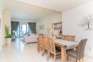 a dining room and living room with a table and chairs at HiGuests - Spacious Apartment next to Dubai Harbour & Marina in Dubai