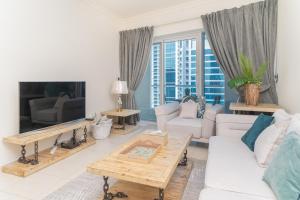 a living room with a white couch and a tv at HiGuests - Spacious Apartment next to Dubai Harbour & Marina in Dubai