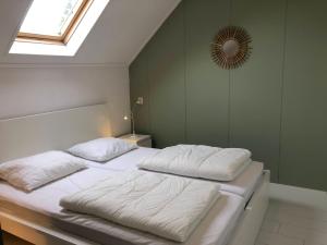 um quarto com duas almofadas brancas numa cama em Naar Zee op Ameland em Buren