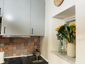 a kitchen with a sink and a vase of flowers at Casa das Férias in Lisbon
