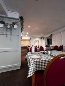 comedor con mesa y mantel a cuadros en The Georgian Hollies Hotel, en Blackpool