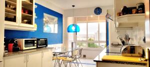 una cucina con pareti blu e tavolo con sedie di TheLBhome-Moderno duplex con terrazas wifi-Netflix a La Coruña
