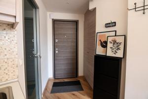 un corridoio con porta nera e pavimento in legno di Gravity Downtown Scandi Studio a Città di Rodi