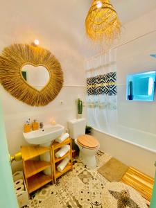 La salle de bains est pourvue d'un lavabo, de toilettes et d'un miroir. dans l'établissement Casa Bali. Duplex con terraza privada en centro, à Vejer de la Frontera