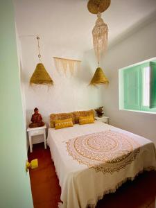 Un dormitorio con una cama con almohadas amarillas. en Casa Bali. Duplex con terraza privada en centro en Vejer de la Frontera