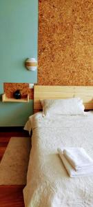 a bedroom with a white bed with a cork wall at Casa Rural Asitxo in Bermeo