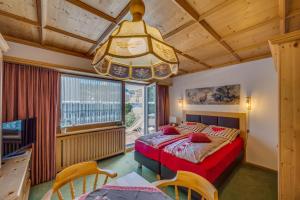 a bedroom with a bed and a chandelier at Apartments Olympiastraße in Seefeld in Tirol