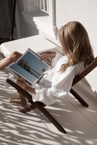 a woman sitting in a chair with a laptop at NOAH House in Cape Town