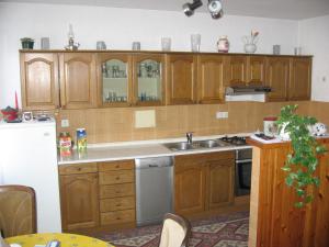 una cocina con armarios de madera y fregadero en Apartment Kalvarija, en Novi Vinodolski