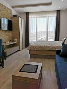 a bedroom with a bed and a blue couch at Apartman Šilja L22 Milmari Kopaonik in Kopaonik