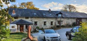 a car parked in front of a stone house at Les quatre vents in Ars