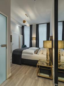 um quarto com uma cama e uma mesa com um candeeiro em BS Boutique Hotel em Heidelberg