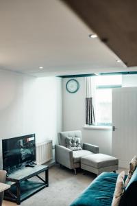 a living room with a couch and a tv at Apartments-DealHouse in Huddersfield