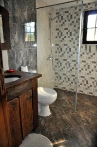 a bathroom with a toilet and a shower and a sink at Миронската къща in Medven