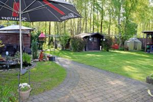 a patio with an umbrella next to a yard at Ferienwohnungen an der Baaber Heide in Baabe