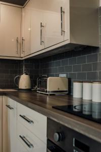 a kitchen with white cabinets and a counter top at Apartments-DealHouse in Huddersfield