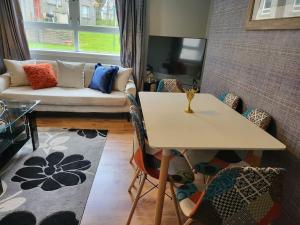 a living room with a table and chairs and a couch at 4 Bedroom Apts at Sensational Stay Serviced Accommodation Aberdeen- Powis Crescent in Aberdeen