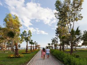a couple walking down a path in a park at Lykia Botanika Beach Fun & Club - All Inclusive in Fethiye