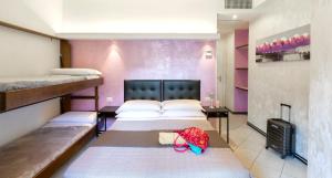 ein Zimmer mit zwei Betten und einem Kind, das auf einem der Betten liegt in der Unterkunft Hotel La Nidiola in Riccione