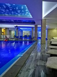 a large swimming pool in a building with blue chairs at Šilja Kopaonik S45 Milmari in Kopaonik