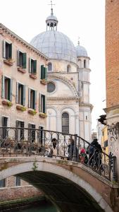 a bridge over a river with a building with a dome at Wendy luxury apartment in Venice