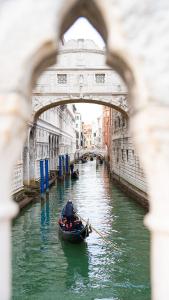 a gondola in a canal under a bridge at Wendy luxury apartment in Venice