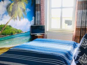 - une chambre avec une peinture murale sur palmier et un lit dans l'établissement Ferienhof - Ferienwohnung, à Gadebusch