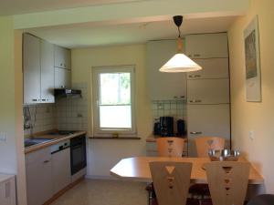 a kitchen with a table and chairs and a window at Ferienhäuser Mittelhof in Bad Berleburg