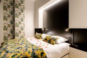 a bedroom with a bed with a floral bedspread at SWEET LEONE JACUZZI PLACE TERREAUX in Lyon