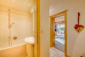 a bathroom with a tub and a sink and a shower at Apartments Olympiastraße in Seefeld in Tirol