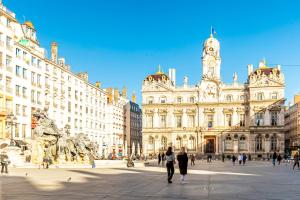 a group of people walking in front of a building at SWEET LEONE JACUZZI PLACE TERREAUX in Lyon